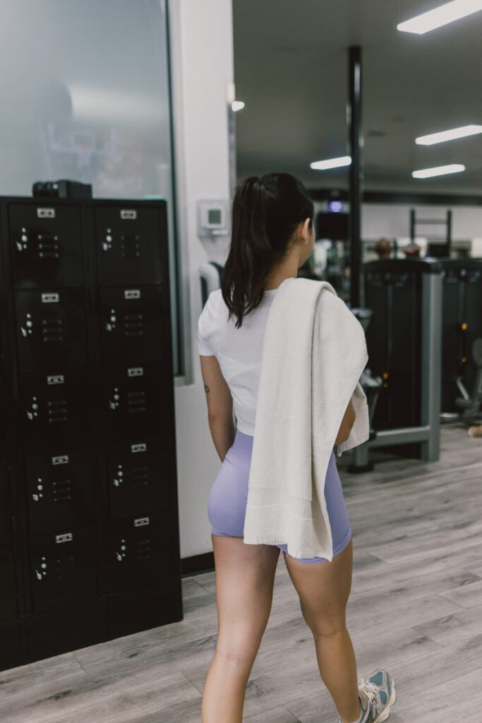 Woman walking into Hydrogen Fitness with towel service